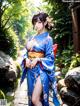 A woman in a blue kimono is posing for a picture.