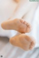 A close up of a person's bare feet on a bed.