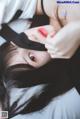 A woman laying on a bed with a mask on her face.