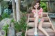 A woman in a red and white bikini sitting on a wooden bench.