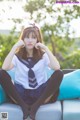 A woman in a school uniform sitting on a blue couch.