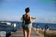 A woman in a bathing suit standing on a dock.