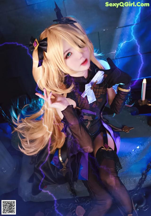 A woman in a black and purple outfit posing for a picture.
