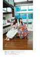 A couple of women sitting on top of a wooden floor.