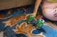 A woman sitting on the floor next to two cans of beer.