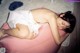 A woman laying on top of a pink bean bag chair.