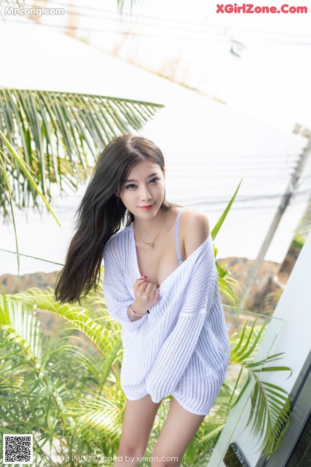 A woman in a white dress posing for a picture.